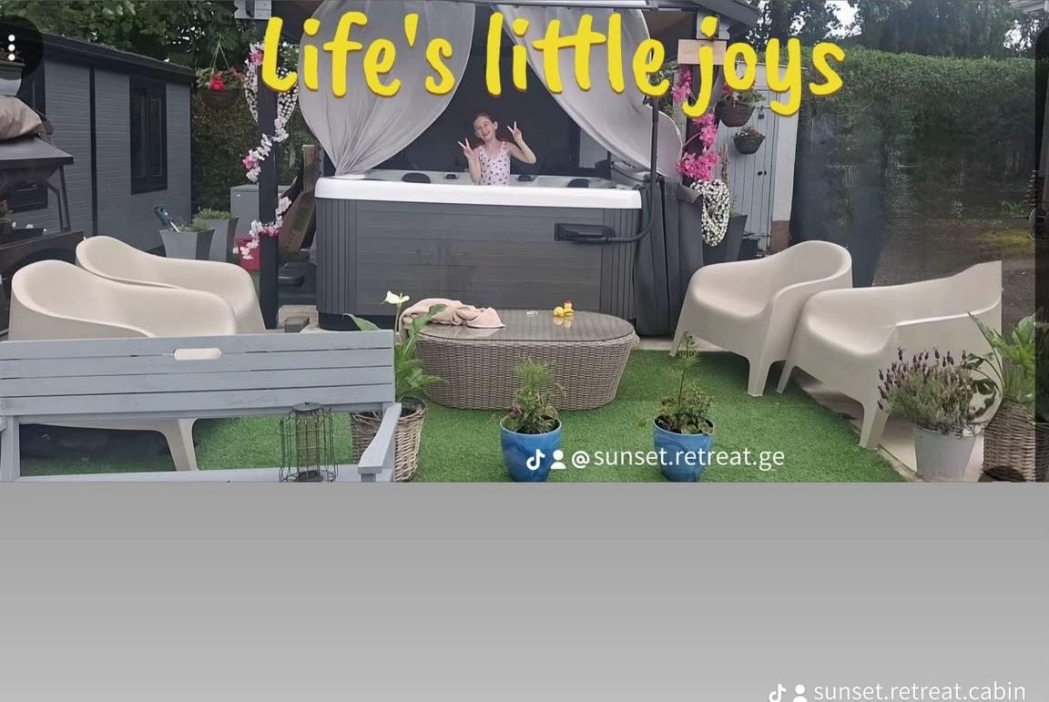 The hot tub and patio seating on the artificial lawn